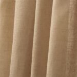 A detailed close-up of the textured weave and soft vertical folds of a tan linen curtain.