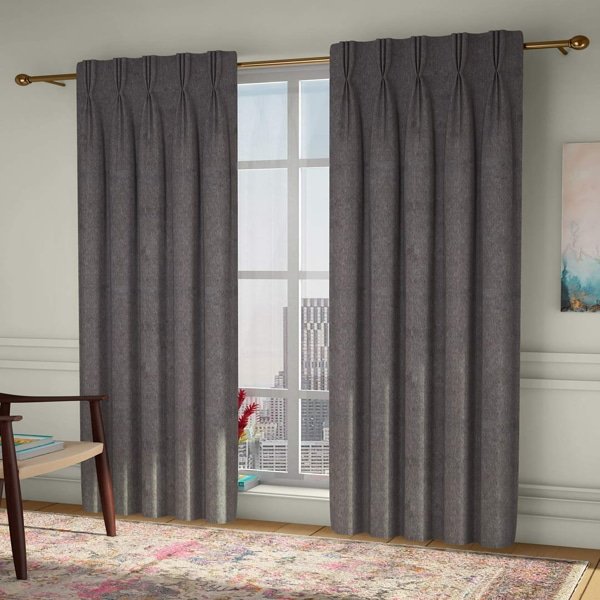 A pair of charcoal gray pinch-pleat curtains framing a large window in a modern living room.