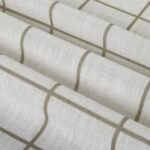 Close-up of white textured linen fabric with a beige windowpane grid pattern.